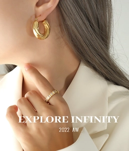 Détail de créoles torsadées dorées et bague en zircon baguette portées par un mannequin