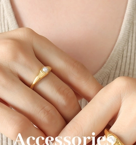 Primo piano di un anello d'oro minimalista con perla bianca sull'indice della donna