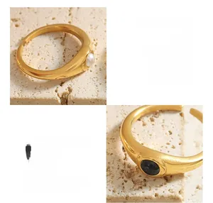 Dettaglio di anelli in acciaio al titanio placcato oro 18K con perline in vetro bianco e nero