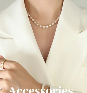 Close-up of elegant freshwater pearl necklace with gold beads on a chic beige blazer