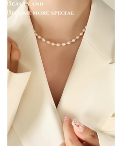 Detail of baroque freshwater pearl necklace with gold spacer beads on a model