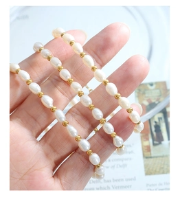 Macro detail of natural freshwater pearls and gold beads on a delicate choker necklace