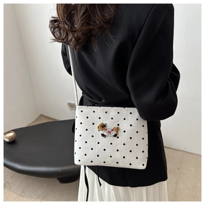 Sac bandoulière à pois avec broderie animale mignonne porté à l'épaule