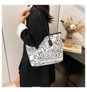Close-up of graffiti print tote bag showing street style illustrations and black straps