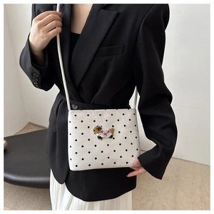 Gros plan du sac à bandoulière blanc à pois avec broderie animale 3D mignonne
