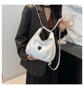 Detail of white hobo bag featuring a fluffy plush dog face and smooth faux leather finish