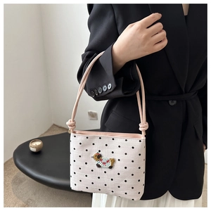 Gros plan du sac seau en toile à pois avec broderie de mouton au design minimaliste
