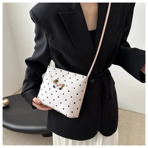 Sac bandoulière à pois avec broderie cartoon porté par un mannequin