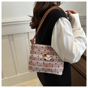 Détail du sac sous l'aisselle à carreaux roses avec broderie chien et dentelle