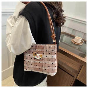 Détail du patch mouton brodé et dentelle sur le sac seau en toile à carreaux