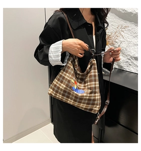 Détail du sac cabas à carreaux marron avec motif cerf et bandoulière ajustable