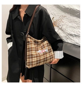 Détail du sac en toile à carreaux avec broderie chien et bandoulière en cuir