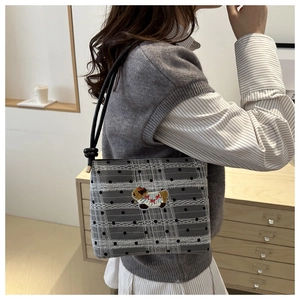 Détail du sac à bandoulière en maille à pois avec dentelle et écusson animal brodé