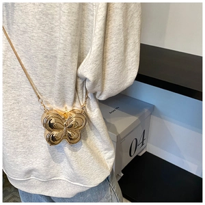 Detail shot of a golden butterfly mini evening clutch bag with metallic mirror finish
