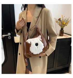 Detail of a shiny brown multi-way bag featuring a plush dog face design on model