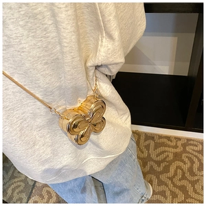 Close-up of a gold butterfly-shaped hard shell evening bag with a sleek metal chain strap