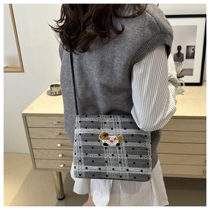 Sac bandoulière à carreaux avec dentelle et écusson animal porté à l'épaule