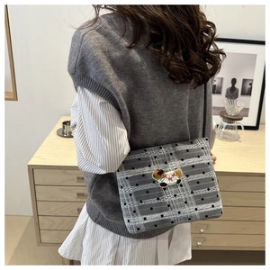 Détail du sac à bandoulière à carreaux avec broderie animale et pois noirs