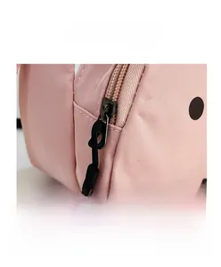 Close-up of pink nylon messenger bag with metal zipper and contrast pattern detail