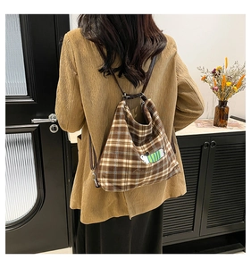 Détail d'un sac à dos vintage à carreaux marron avec broderie d'animaux mignons