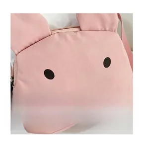 Close-up of pink canvas rabbit crossbody bag with cute ears and premium metal zipper