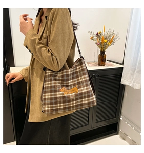 Détail du sac cabas à carreaux avec broderie de teckel et bandoulière en cuir