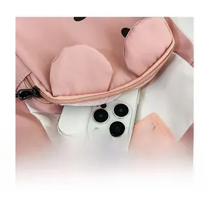 Front zipper pocket of pink crossbody bag showing storage space for a smartphone
