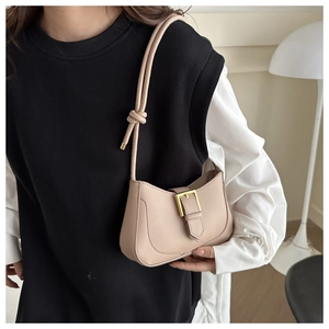 Gros plan du sac croissant beige avec boucle en métal vintage et bandoulière à nœud chic