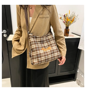 Détail d'un sac cabas à carreaux marron avec imprimé teckel et bandoulière réglable