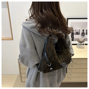 Lifestyle-Foto der großen Leopard-Beuteltasche mit Lederriemen und Metallringen