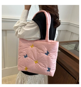 Pink quilted nylon tote bag featuring blue butterfly embroidery on a spacious shoulder bag