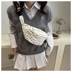 Detailed view of white saddle bag with colorful polka dots and double zipper straps
