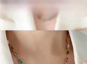 Detailed view of model wearing a gold necklace with multi-colored baguette-cut rhinestones