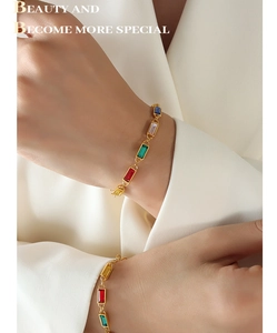 Detailed shot of a gold chain bracelet with colorful rectangular-cut gemstone inlays