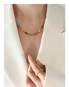 Close-up of a model wearing colorful rhinestone necklace and matching gold ring set