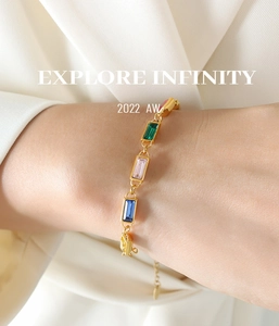 Detailed shot of a gold chain bracelet with colorful rectangular rhinestones on a wrist