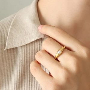 Elegante anello placcato oro con perla bianca rotonda su una fascia larga sagomata