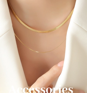 Detail of layered gold titanium necklace featuring a sleek flat snake chain and a fine chain