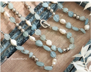 Détail macro du collier bohème avec perles d'eau douce et pierres naturelles bleues
