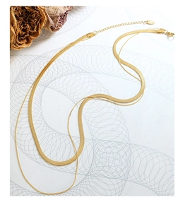 Detail of gold double-layered snake chain necklace with K18 engraving on white background
