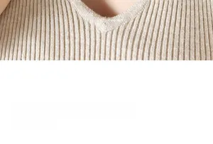 Détail d'un pull en maille côtelée beige avec col en V et rayures verticales fines
