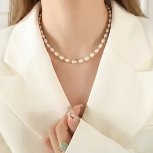 French baroque freshwater pearl necklace with gold beads on a beige blazer model