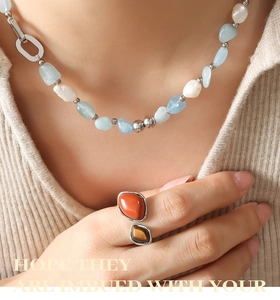 Détail du collier de perles d'eau douce et pierre bleue avec une bague en argent à deux pierres