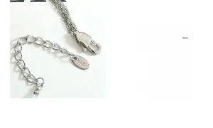 Détail du fermoir mousqueton gravé K18 et de la chaîne d'extension d'un collier argenté