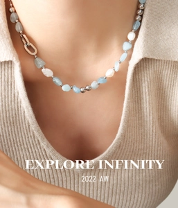 Détail d'un collier bohème avec pierres bleues et perles sur un col en tricot