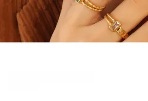 Détail d'une bague dorée torsadée avec zircon sur fond en velours côtelé marron
