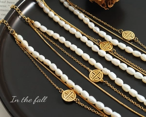 Detail of triple-layer bracelet with irregular freshwater pearls and gold Fu charm