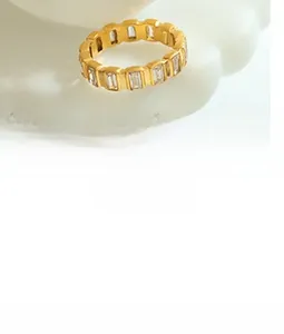 Close-up of golden ring featuring emerald-cut cubic zirconia in a step-cut setting