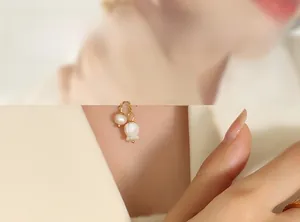 Detail of lily of the valley pendant with fresh water pearl on gold triple layer bracelet
