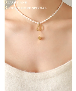 Detail of freshwater pearl necklace with gold letter D pendant and square tassel charm